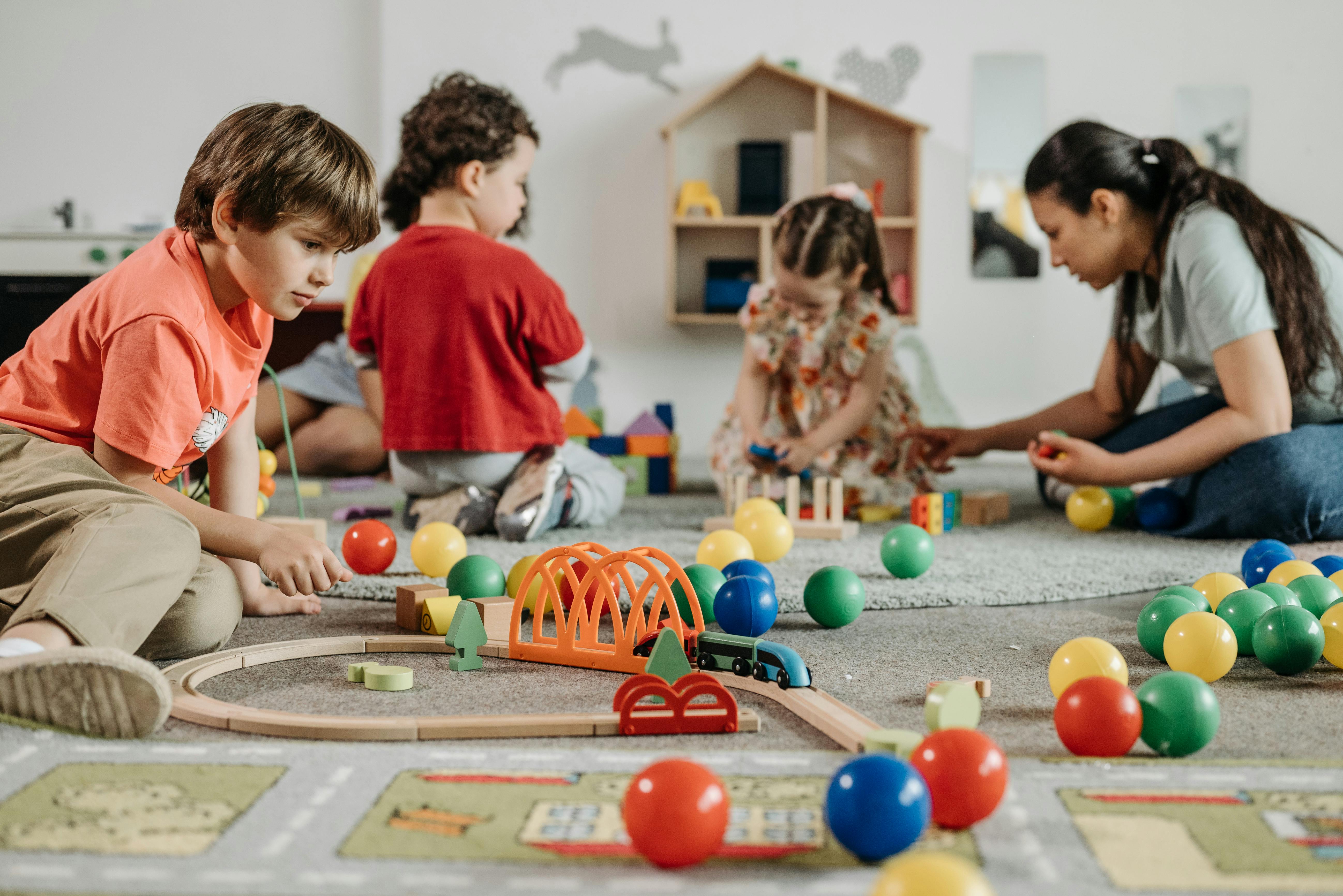 Children playing with toys supervised by teacher